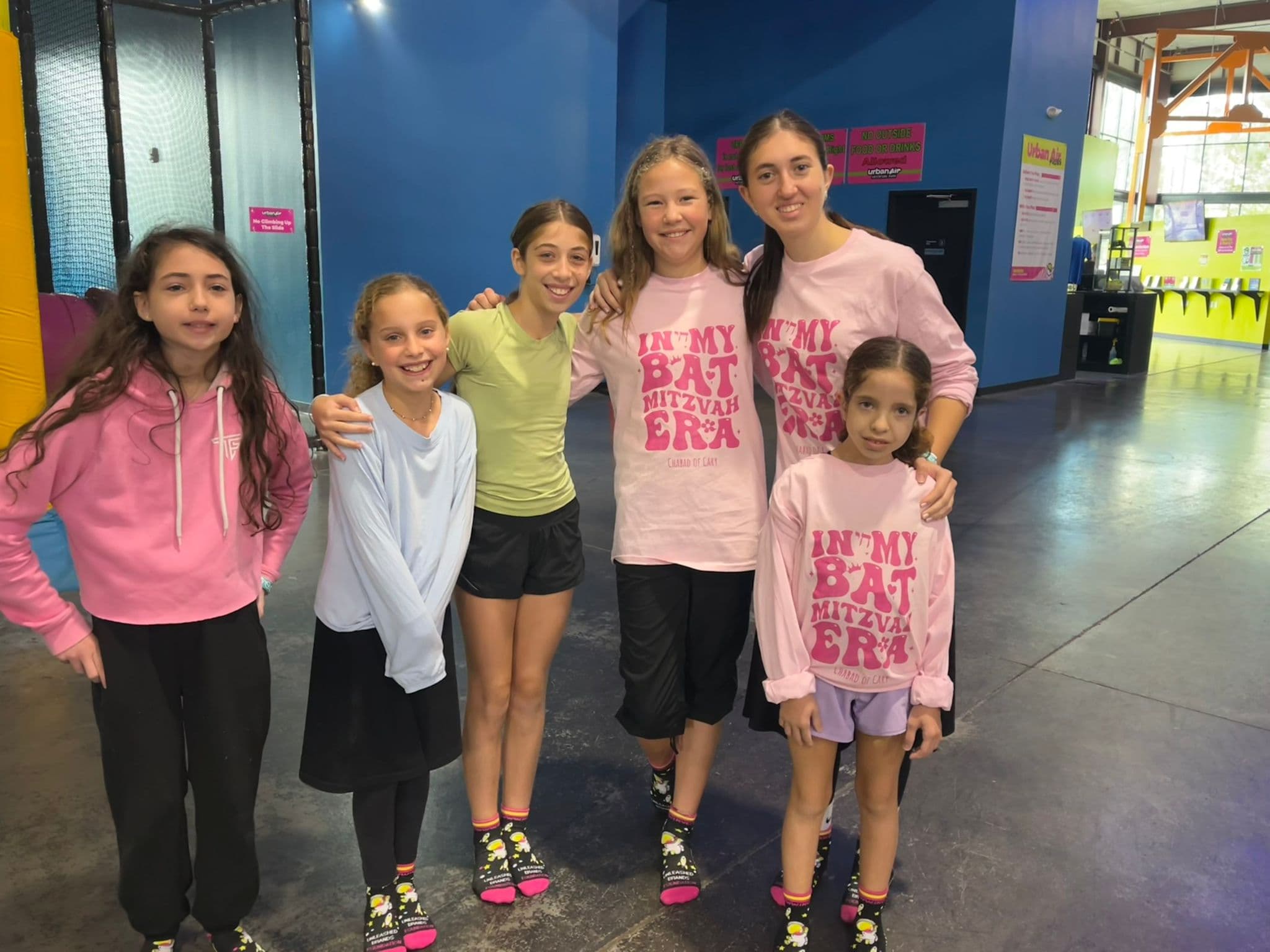 Girls at a trampoline park in matching Chabad of Cary shirts