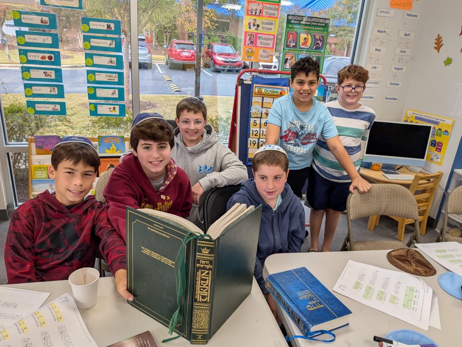 Boys in kippot studying an open Hebrew Chumash together